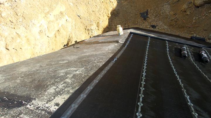 Première couche d'imprégnation de goudron liquide pour une accroche maximale sur la surface béton