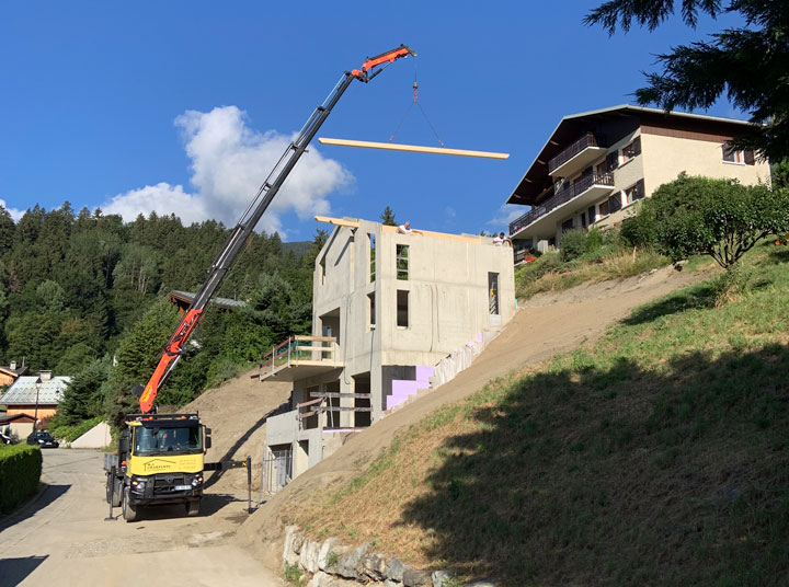 Camion-grue possant les pannes de la charpente