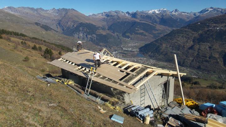 Les panneaux d'isolant et les rouleaux de goudron sont en attente pour la prochaine étape de la couverture